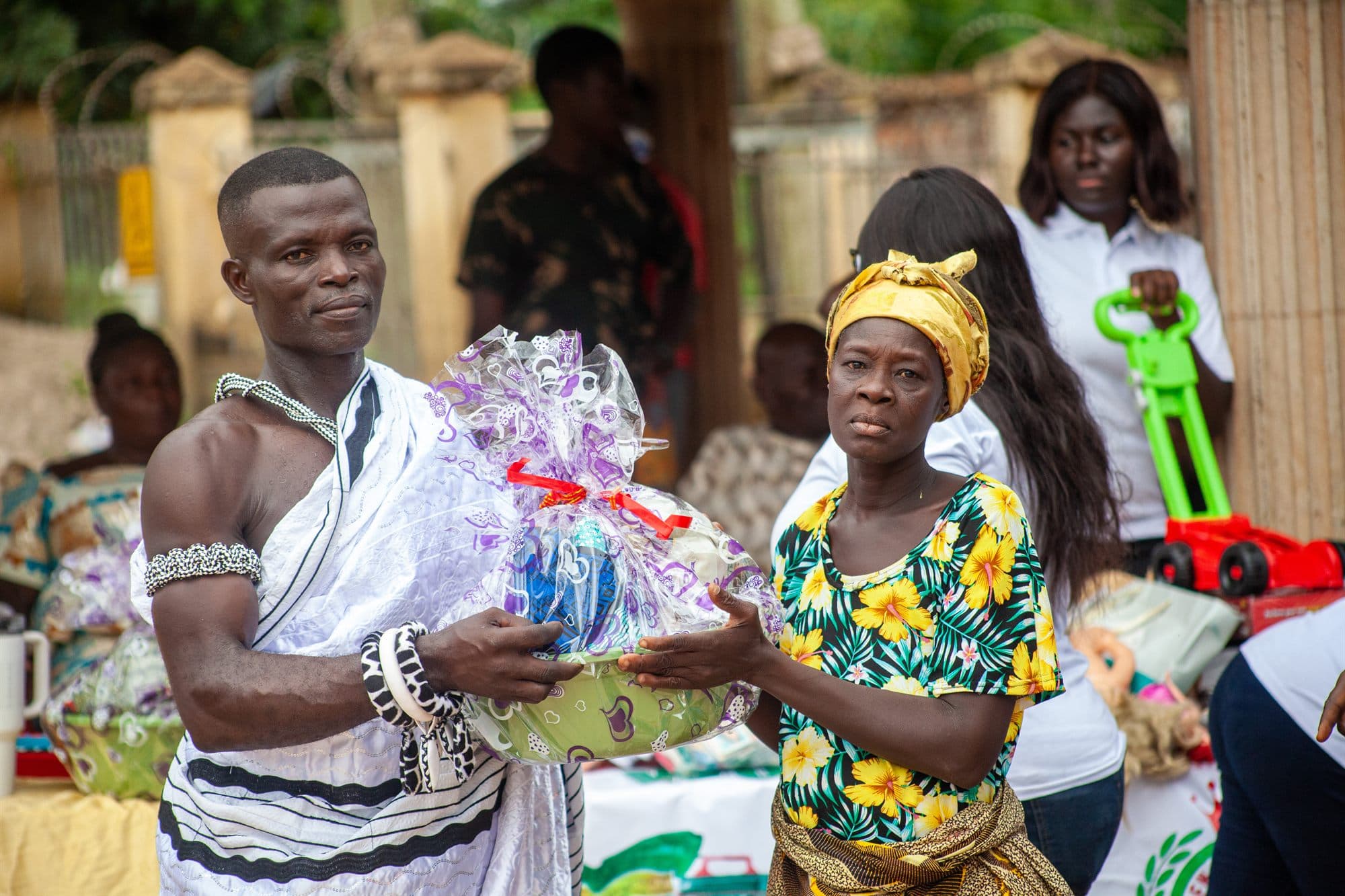 A community elder receiving a wrapped gift hamper at a Women of the Kingdom outreach