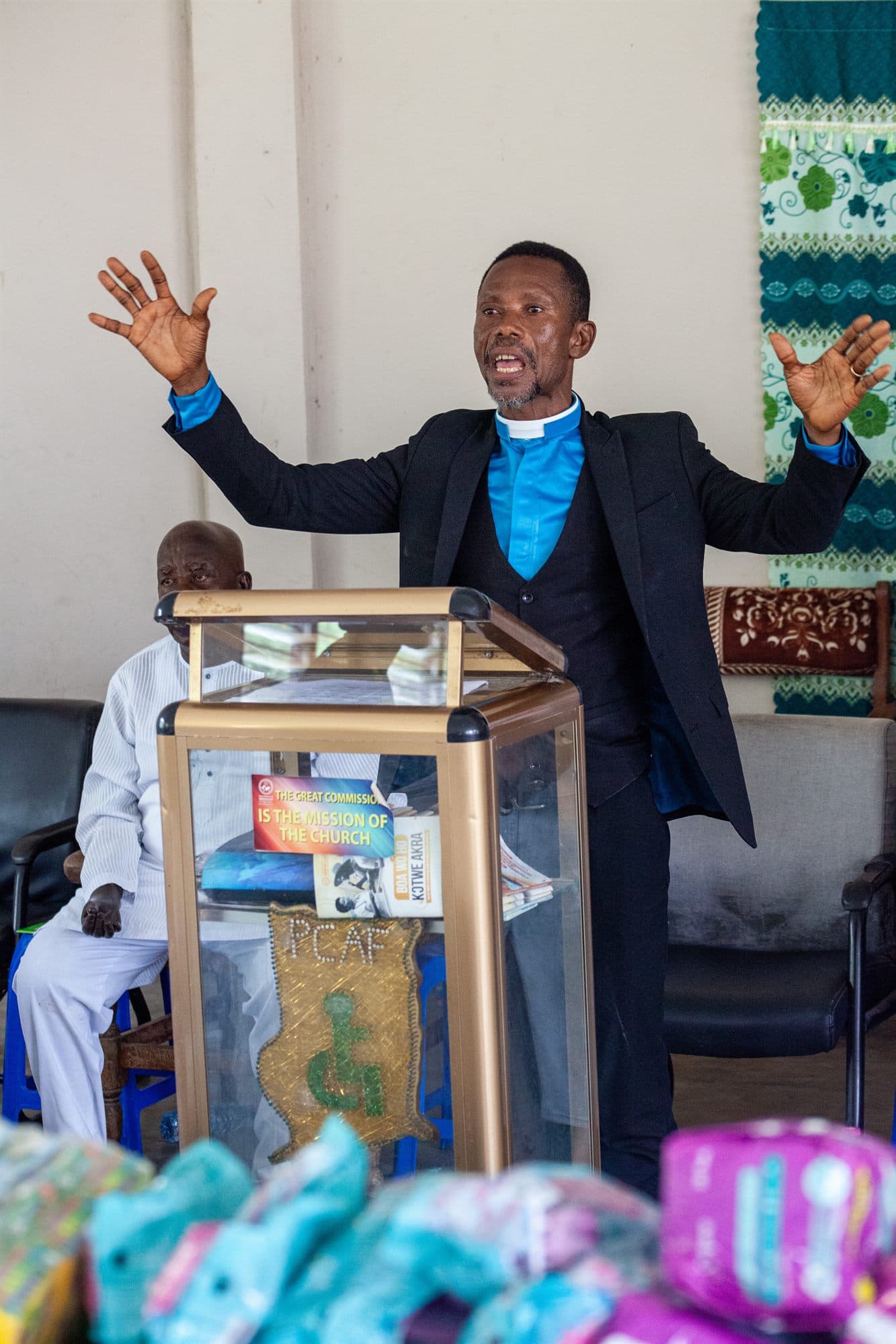 A pastor speaking at a podium during a Women of the Kingdom gathering