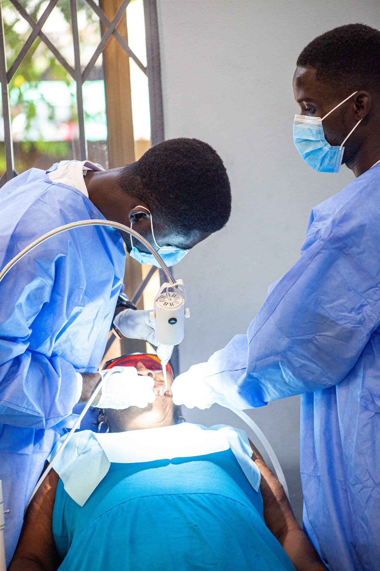 A medic in scrubs attending to a patient at a community health screening