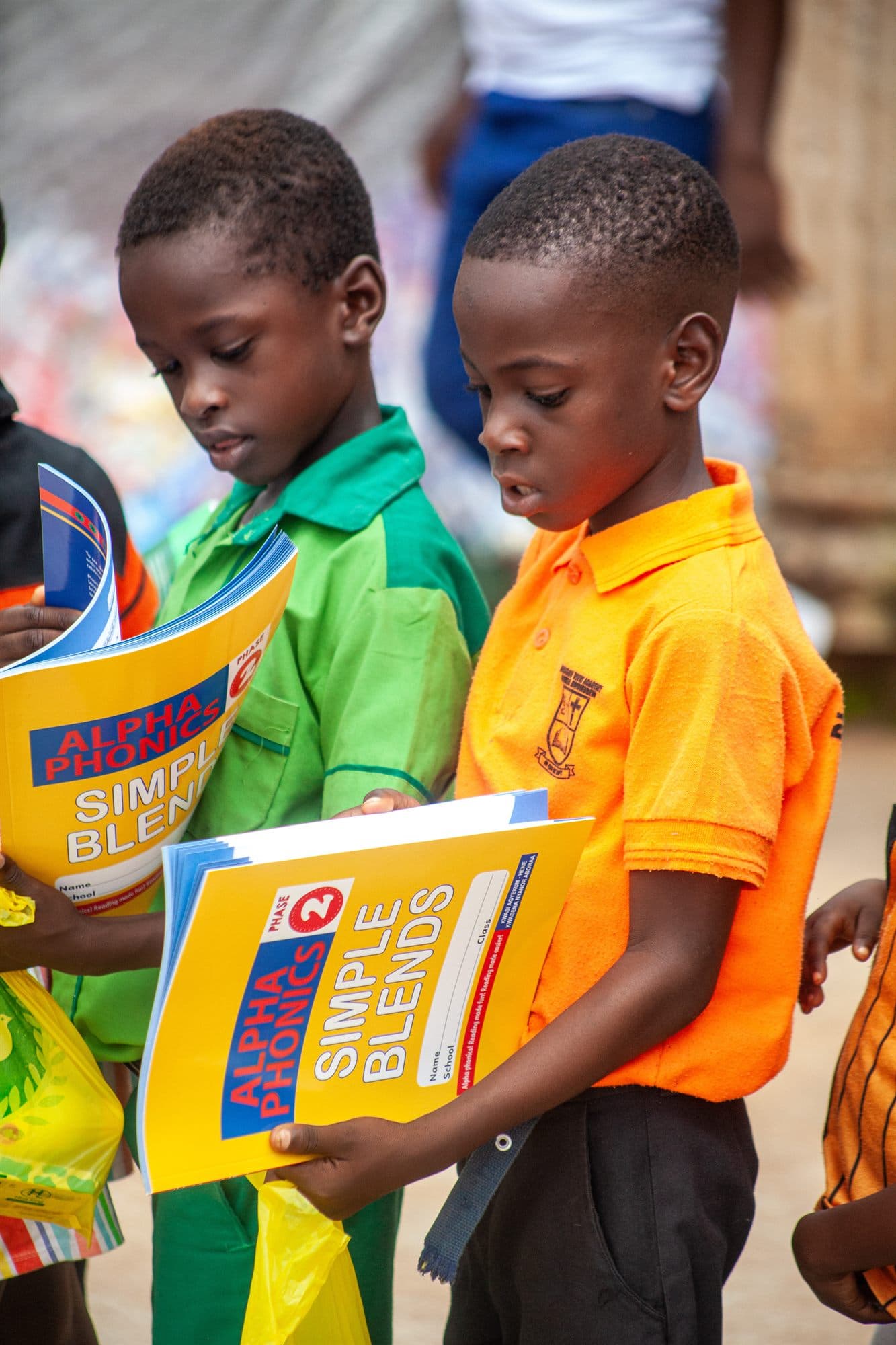 Two boys proudly holding up their donated exercise books
