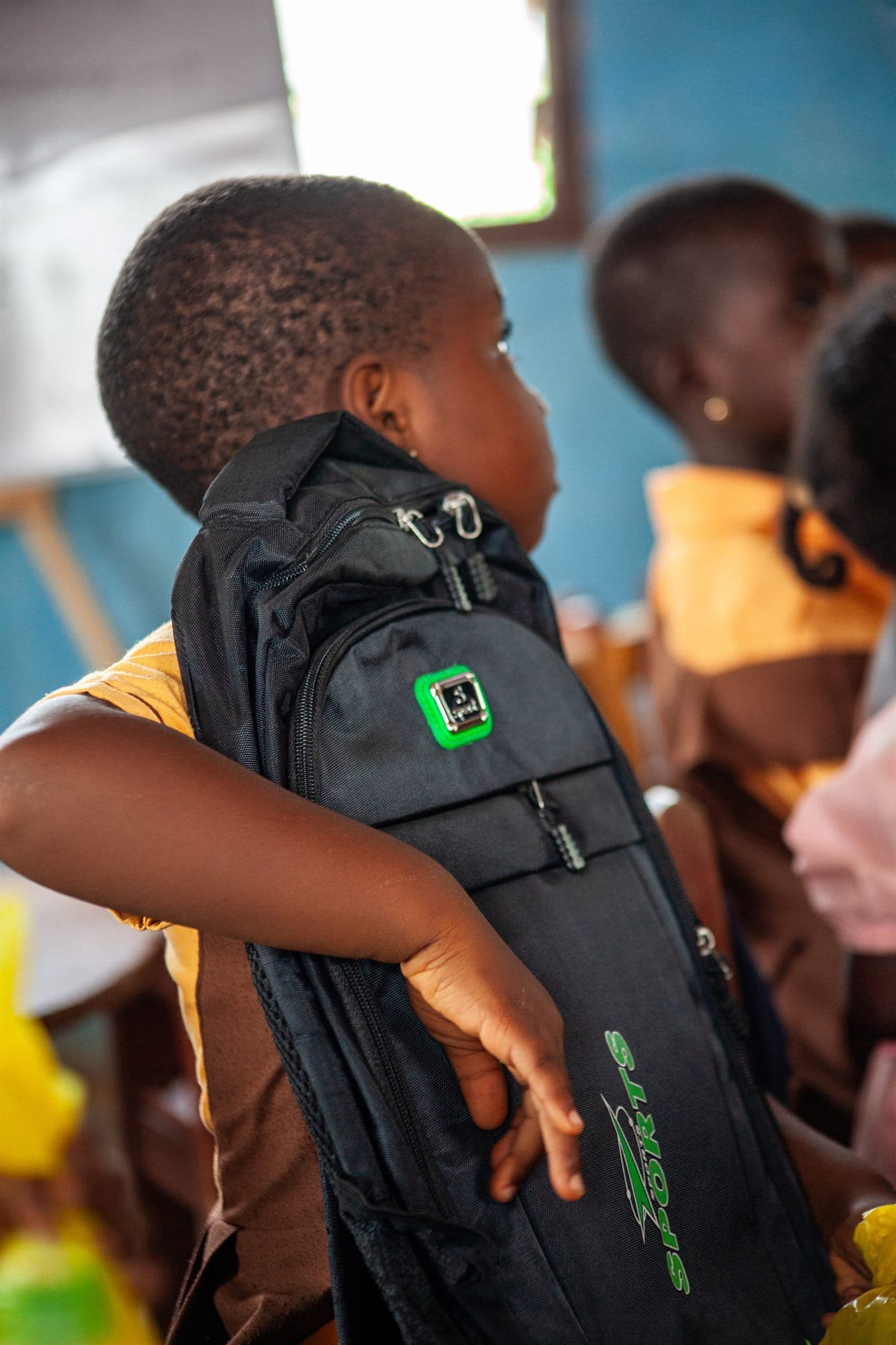 A boy trying on his new backpack at a distribution day
