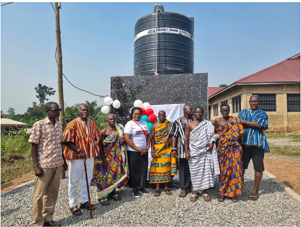 Chiefs, elders and Mrs. Hannah Brock in front of the newly commissioned Women of the Kingdom borehole and water tank