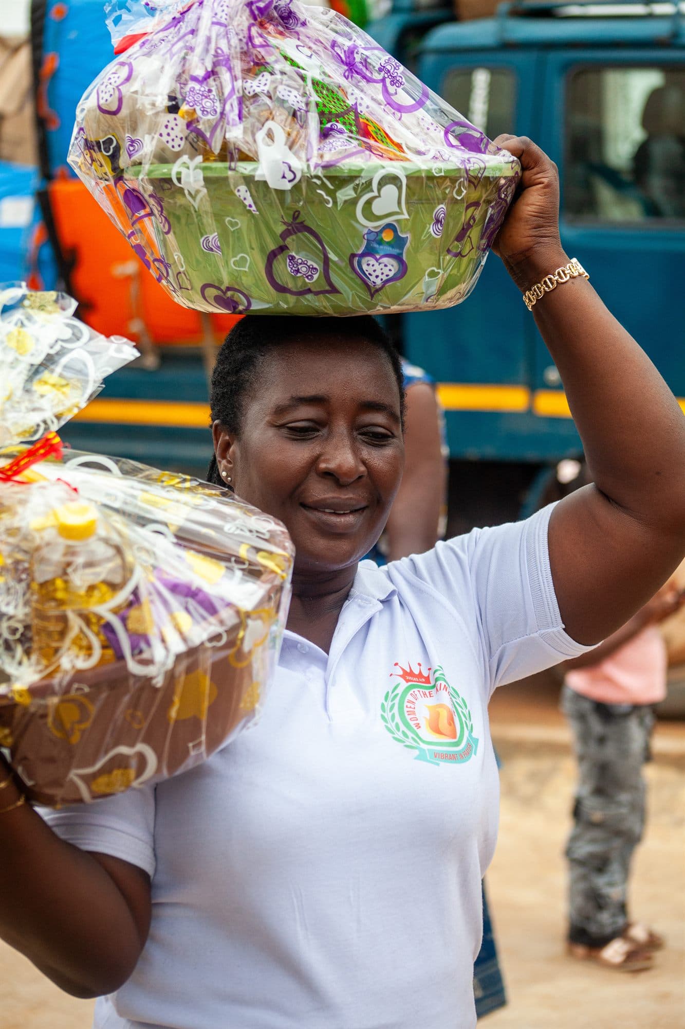 A volunteer balancing a wrapped hamper on her head at the outreach